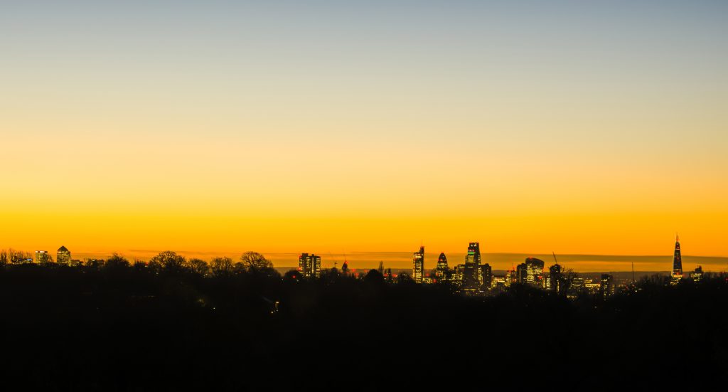 Sunrise and dawn in winter over the London skyline from Canary Wharf to The Shard, taken from Hampstead Heath, London