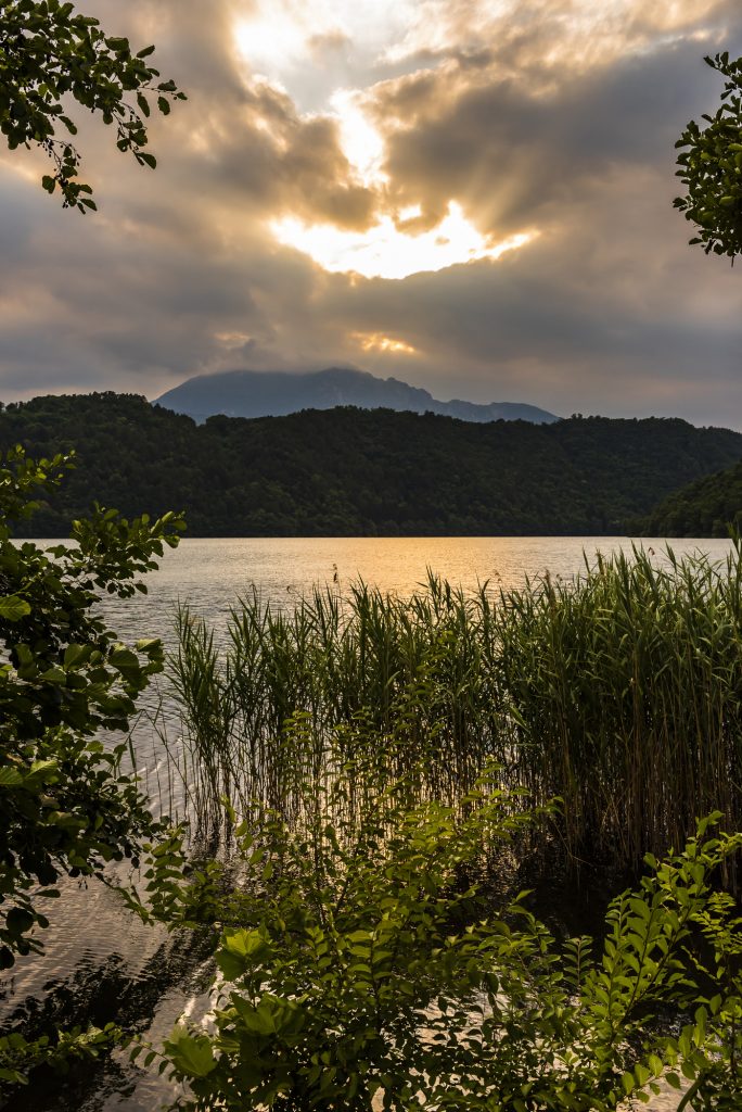 Sunset and stormy clouds over the lake at Levico Terme in the Dolomite mountains, Trentino, Italy