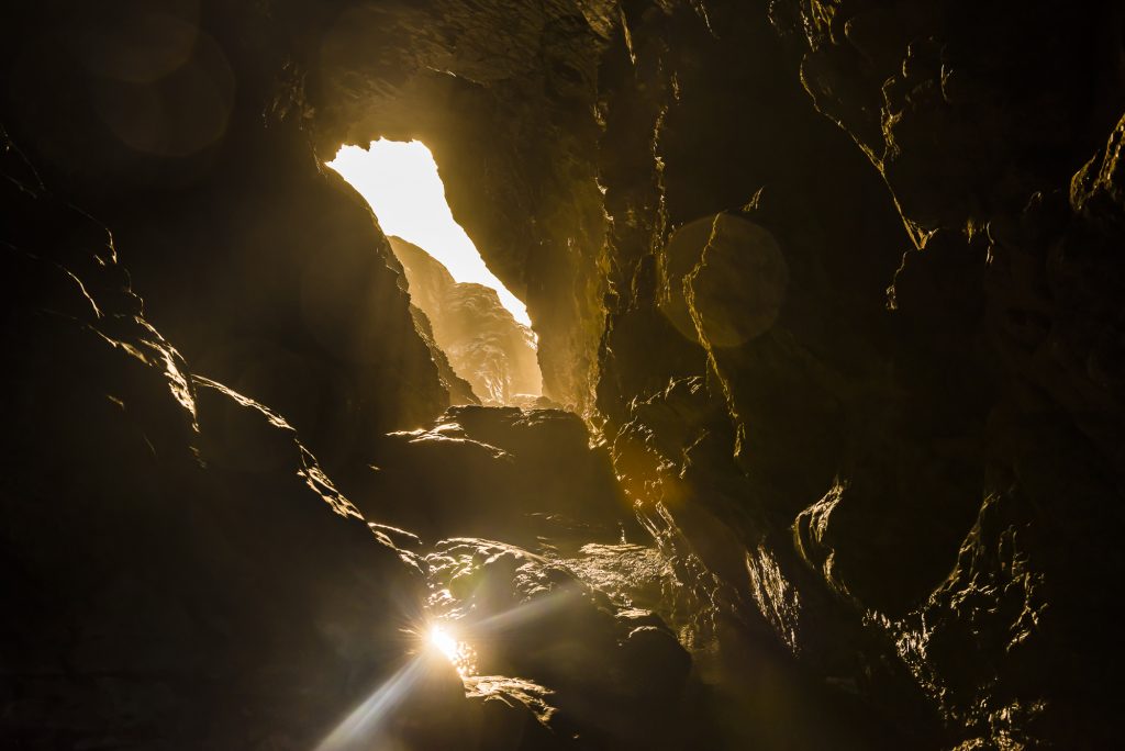 Late afternoon autumn sunlight through Merlin's Cave, Tintagel, Cornwall