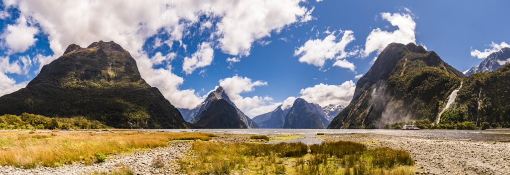 Panorama over the beach, mountains, fjords and snowy waterfalls at Milford Sound in Fjordland, Southland, South Island, New Zealand