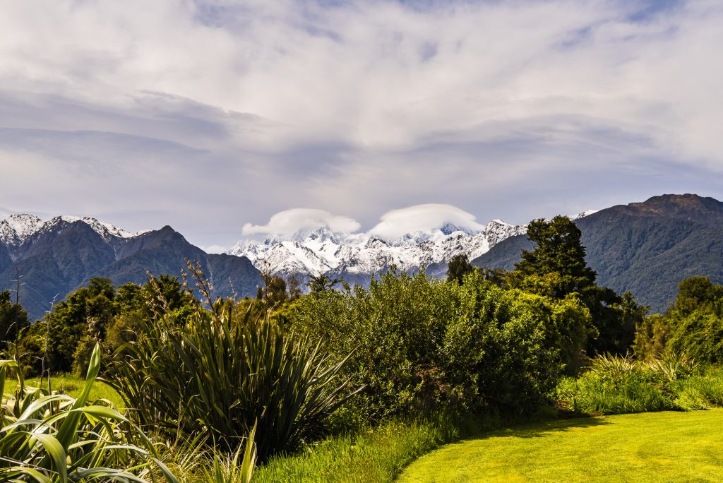 The snowy springtime mountain tops of Mount Tasman and Mount Cook, in low cloud, West Coast, South Island, New Zealand