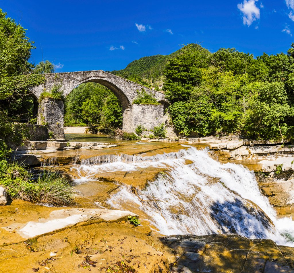 The medieval bridge of Ponte della Brusia and waterfall at Bocconi, Emilia-Romagna, Italy