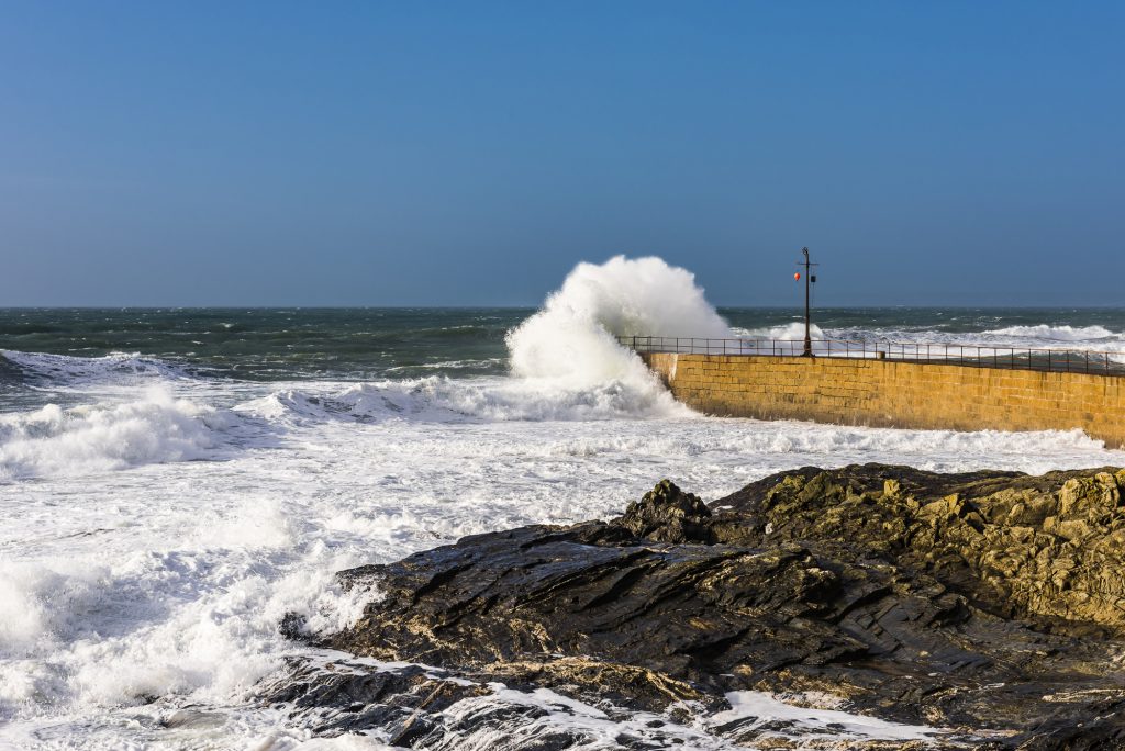 Crashing waves and surf on the harbour wall at Porthleven, near Penzance, Cornwall