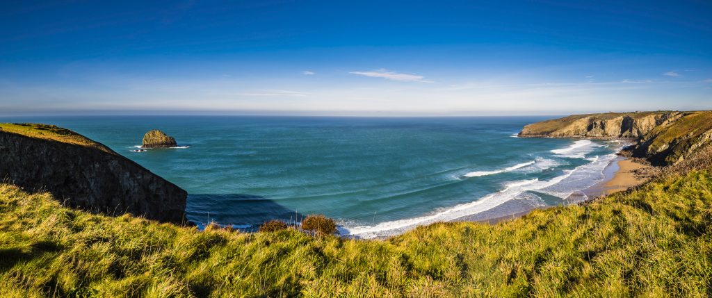 Panorama of the early morning winter sunlight over Trebarwith Strand beach, near Tintagel, Cornwall