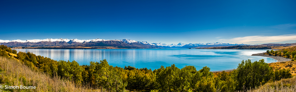 Morning autumnal landscape panorama at Lake Pukaki with snowy mountains and Mount Cook (Aoraki) in the distance, Canterbury, South Island, New Zealand