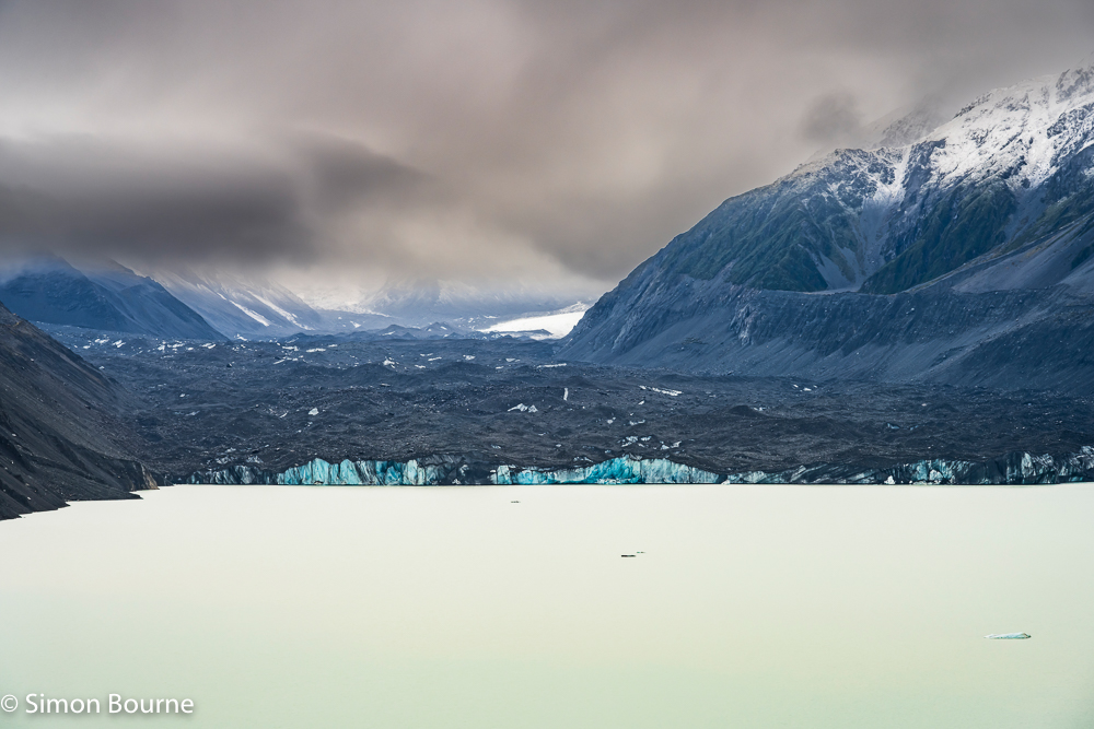 Close up in autumn of the blue ice at the front of the Tasman Glacier and milky Tasman Lake in the Mount Cook National Park, Canterbury, South Island, New Zealand
