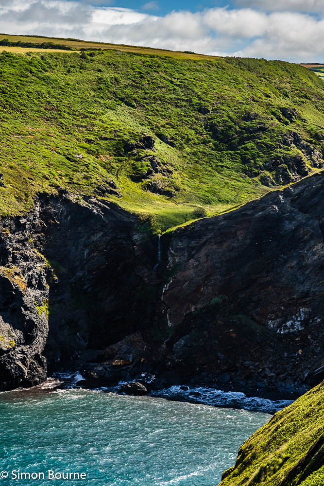 Pentargon Falls waterfall, beach and surf near Boscastle on a sunny summer's morning, Cornwall