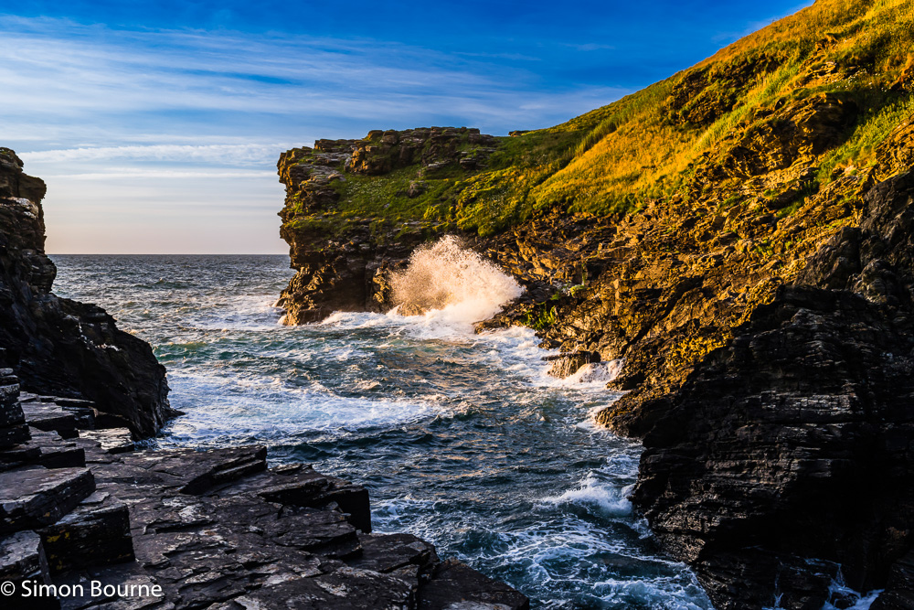 Sunset, orange glow and Atlantic Ocean surf at Rocky Valley, between Tintagel & Boscastle, Cornwall