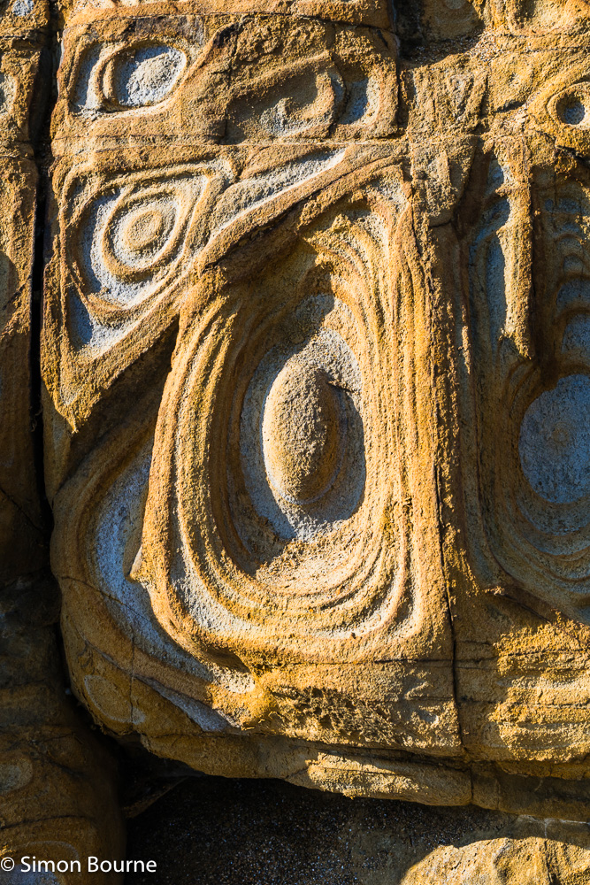 Natural rock formations and concentric rings in the sandstones at Widemouth Sand beach, Cornwall